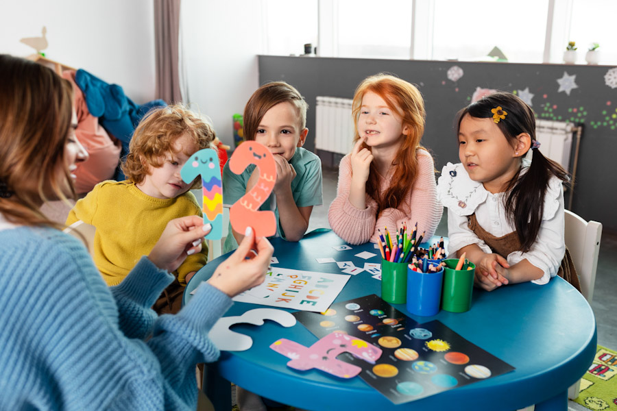 Kurs Erste Hilfe am Kind für Fachpersonal: Eine pädagogische Fachkraft betreut eine Kindergruppe im Kindergarten.